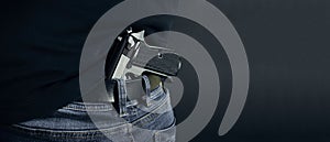 Terrorist thief man holding gun in his hand. Hidden gun. Isolated on dark background. copy space.