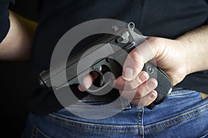Terrorist thief man holding short gun in his hand. Hidden gun on back side body