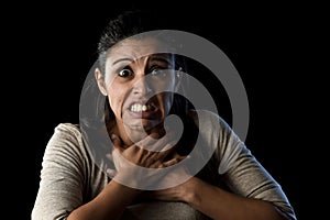 Terrorized and horrified woman desperate and scared isolated on black