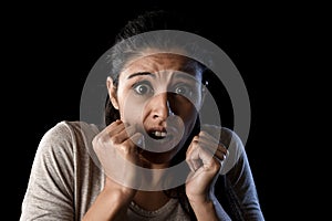 Terrorized and horrified woman desperate and scared isolated on black photo