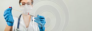 Test for coronavirus Covid-19. Female doctor or nurse doing lab analysis of a nasal swab in a hospital laboratory.