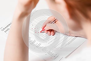 Test of English multiple choice on table.Woman takes an entrance exam