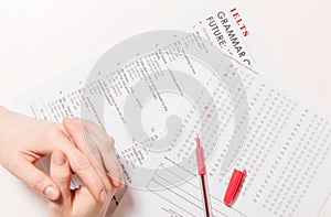 Test of English multiple choice on table. Woman takes an entrance exam