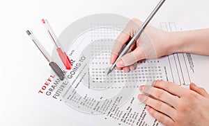 Test of English multiple choice on table. Woman takes an entrance exam