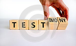 Test or testimony symbol. Businessman turns wooden cubes and changes the word `test` to `testimony`. Beautiful white backgroun