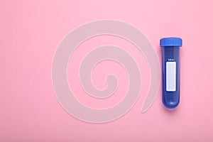 Test tube with liquid on pink background, top view and space for text. Kids chemical experiment toy