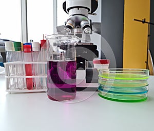 Test tube with purple liquid and multicolored liquids is examined in laboratory