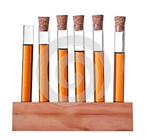 Test tubes with brown liquid in stand on white background