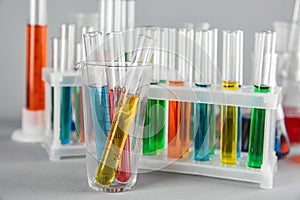 Test tubes with colorful liquids in beaker on table