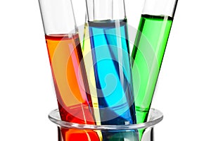 Test tubes with colorful liquids in glass beaker on white background, closeup
