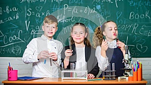 Test tubes with colorful substances. School laboratory. Group school pupils study chemical liquids. Girls and boy