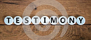 Testimony symbol. White circles with the word `testimony`. Beautiful wooden background. Business, testimony concept. Copy space