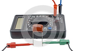 Testing capacitor with multimeter on white