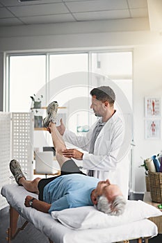 Testing the movement in all his muscles. a young male physiotherapist assisting a senior patient in recovery.