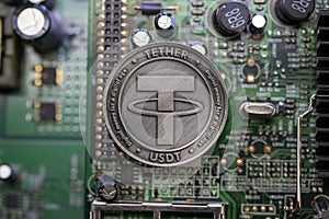 Tether USDT cryptocurrency physical coin placed on computer micro sheme