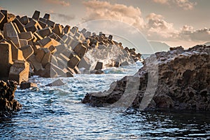 Tetrapods structures on the beach during sunset or dusk as protection for big waves in Wakamatsu, Fukuoka, Japan.