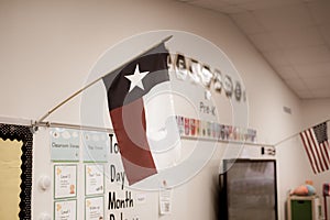 Texas and American flags proudly display in pre-kindergarten classroom near Dallas, modern preschooler class furniture, bulletin