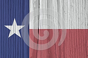 Texas state flag on dry wooden surface with pale, faded colors. Background, wallpaper or backdrop made of old wood with the symbol