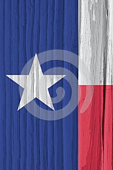 Texas state flag on dry wooden surface. Vertical bright background, wallpaper or backdrop made of old wood. The symbol of one of