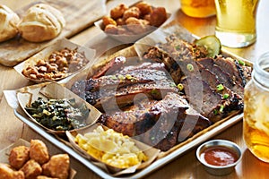 Texas style bbq tray with smoked brisket, st louis ribs, pulled pork, chicken, hot links, and sides photo