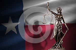 Texas US state flag with statue of lady justice and judicial scales in dark room. Concept of judgement and punishment