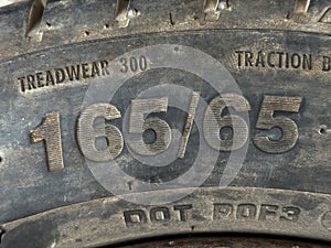 The text 165 65 showing width and aspect ratio of a tyre