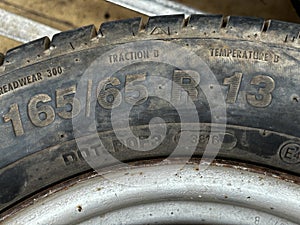 The text 165 65 showing width and aspect ratio of a tyre