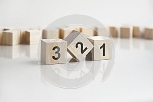 text 321 on wooden blocks with letters on a white background. reflection of the caption on the mirrored surface of the