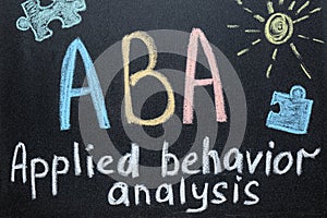 Text ABA Applied behavior analysis and drawings on blackboard