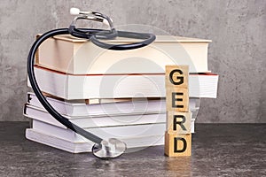 Text abbreviation on wood cubes blocks on gray background. GERD - short for gastroesophageal reflux disease