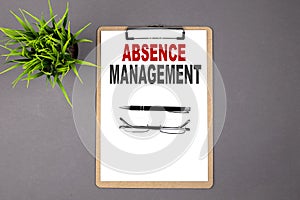 Text ABSENCE MANAGEMENT on the brown clipboard on the grey background. Business concept
