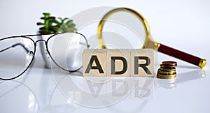 Text ADR on wooden block on the white background