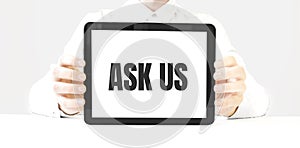 Text aSK US on tablet display in businessman hands on the white bakcground. Business concept