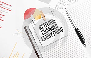 text Attitude Changes Everything on stickers on the diary with office tools