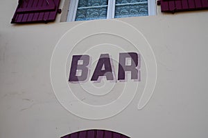 Text bar on facade wall front building cafe pub in street