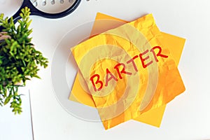 Text barter on crumpled yellow paper, concept