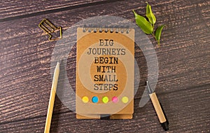 Text big journeys begin with small steps on note paper