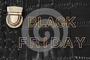 Text Black Friday from golden words on leather handbag background, concept of promotion shopping, seasonal discounts