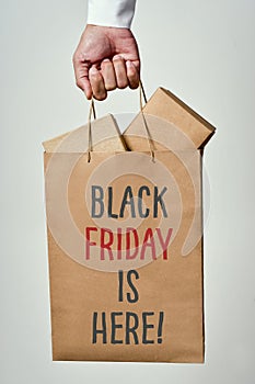 Text black friday is here in a shopping bag