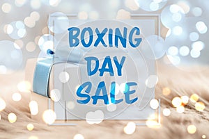 Text Boxing Day Sale and gift with Christmas lights on background