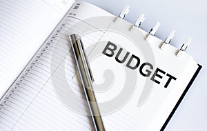 Text BUDGET on the short note texture background with pen