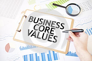 Text BUSINESS CORE VALUES on white paper sheet and marker on businessman hand on the diagram. Business concept