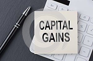 Text CAPITAL GAINS on the sticker on the calculator, business concept