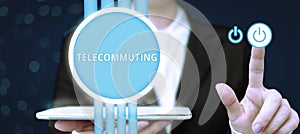 Text caption presenting Telecommuting. Concept meaning work at home using an electronic linkup with central office