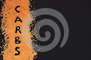 Text carbs on scattering orange pees on black background