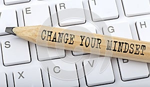 Text CHANGE YOUR MINDSET on wooden pencil on white keyboard. Business concept