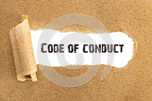 The text Code of conduct appearing behind torn brown paper