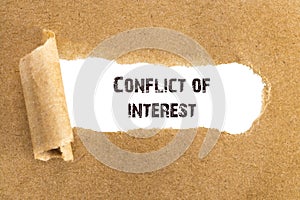 The text Conflict of interest appearing behind torn brown paper