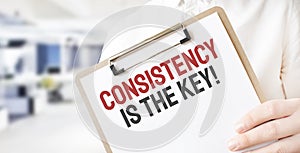 Text Consistency is the key on white paper plate in businessman hands in office. Business concept