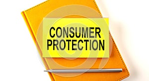 Text CONSUMER PROTECTION on sticker on the yellow notebook